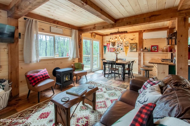 living area featuring a wood stove, wooden ceiling, wooden walls, and an AC wall unit