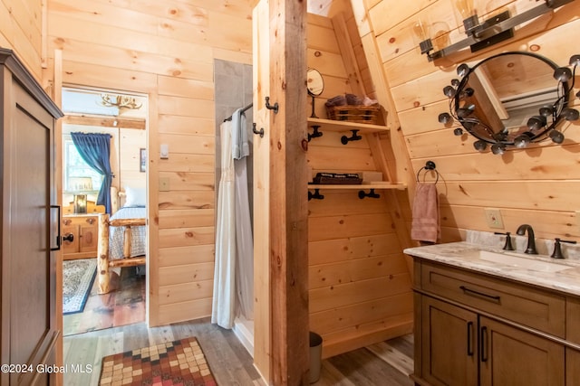 bathroom with curtained shower, wood walls, vanity, and wood finished floors