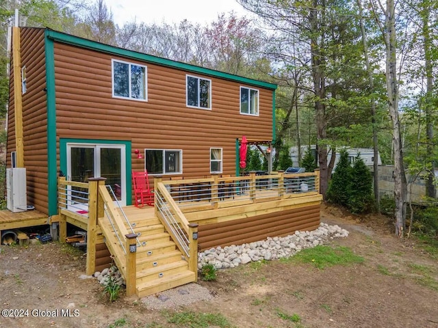 back of house featuring log veneer siding and a deck