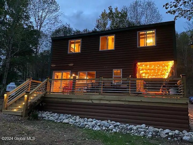 rear view of property featuring log veneer siding and a wooden deck