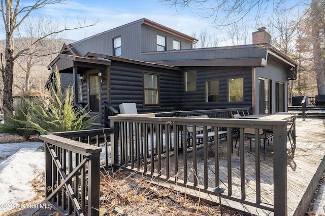 exterior space with a deck and a chimney