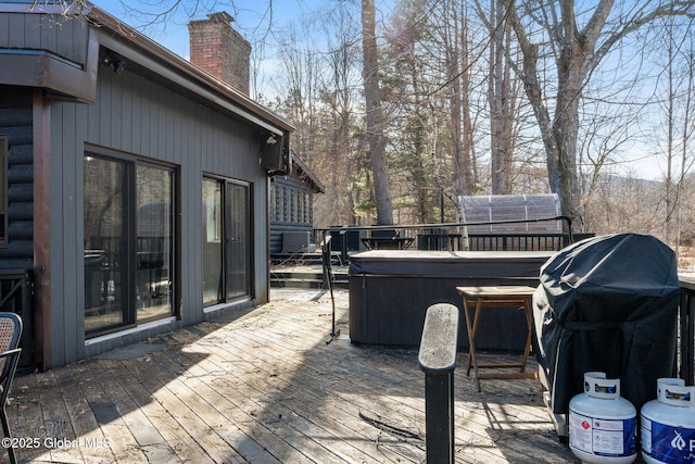 wooden terrace with a hot tub and grilling area