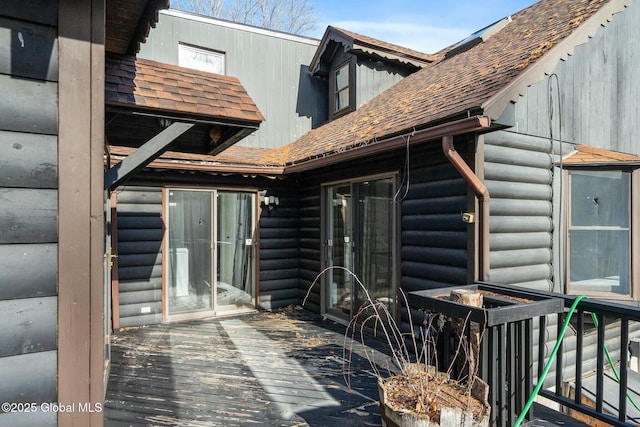 exterior space featuring roof with shingles and a wooden deck