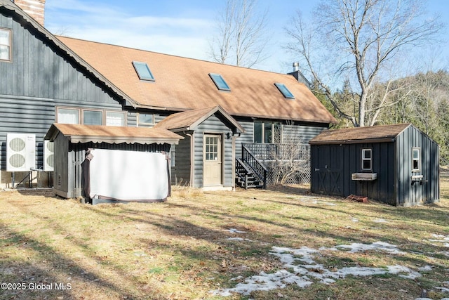 rear view of property with an outbuilding, a lawn, and a shed