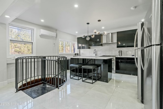 kitchen with light countertops, backsplash, a wall mounted AC, appliances with stainless steel finishes, and wall chimney exhaust hood