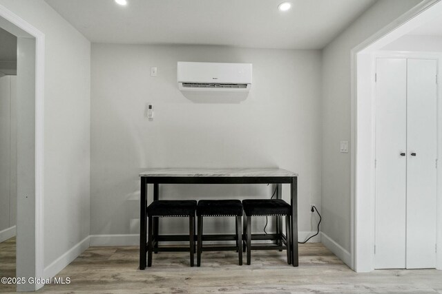 dining space with recessed lighting, wood finished floors, baseboards, and a wall mounted AC