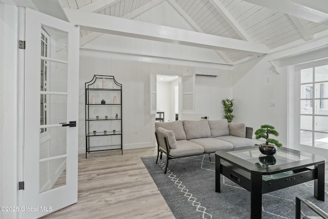 living area with lofted ceiling with beams, baseboards, and wood finished floors