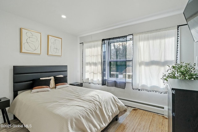 bedroom with recessed lighting, baseboard heating, and wood finished floors