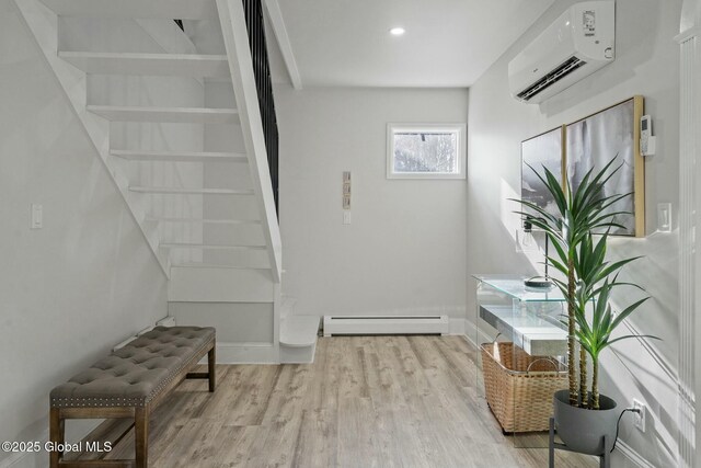 interior space with a wall unit AC, baseboards, a baseboard heating unit, and wood finished floors