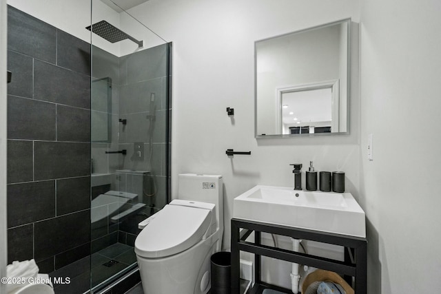 full bathroom with tiled shower, vanity, and toilet