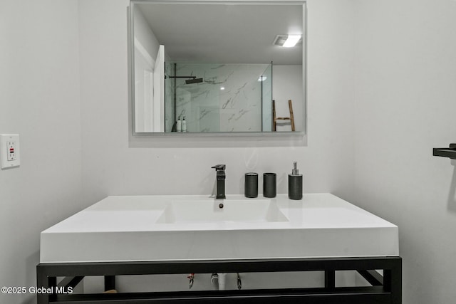 full bathroom featuring a marble finish shower and vanity