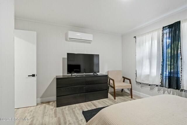 bedroom with baseboards, a wall mounted air conditioner, wood finished floors, and crown molding