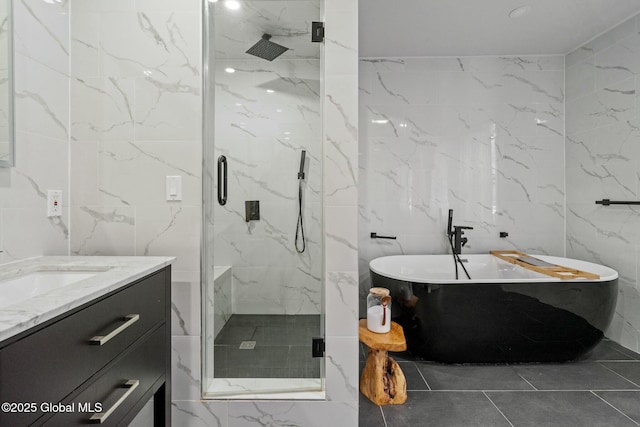 bathroom with a freestanding tub, a marble finish shower, and vanity