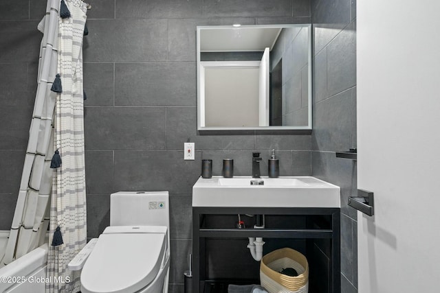 bathroom with shower / tub combo, tile walls, toilet, vanity, and backsplash