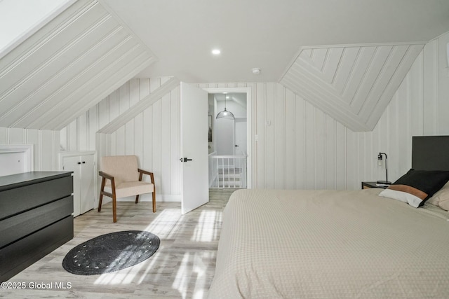 bedroom with vaulted ceiling and wood finished floors