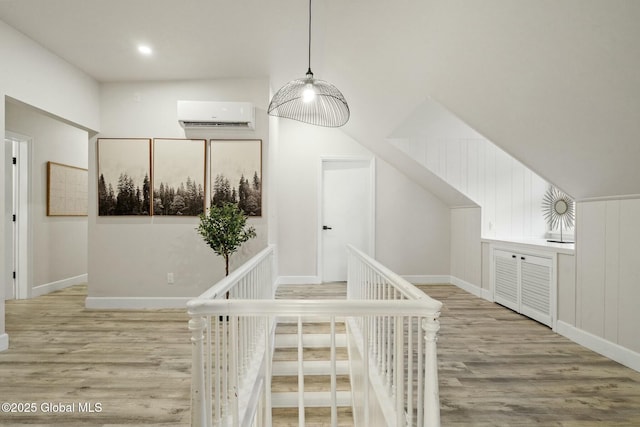 bonus room with baseboards, wood finished floors, and a wall mounted air conditioner