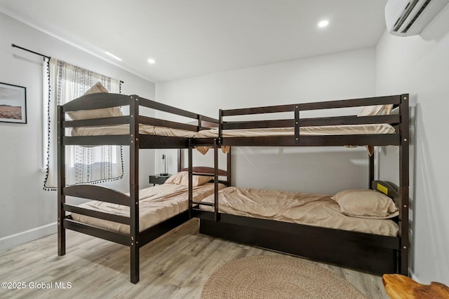 bedroom featuring recessed lighting, baseboards, an AC wall unit, and wood finished floors