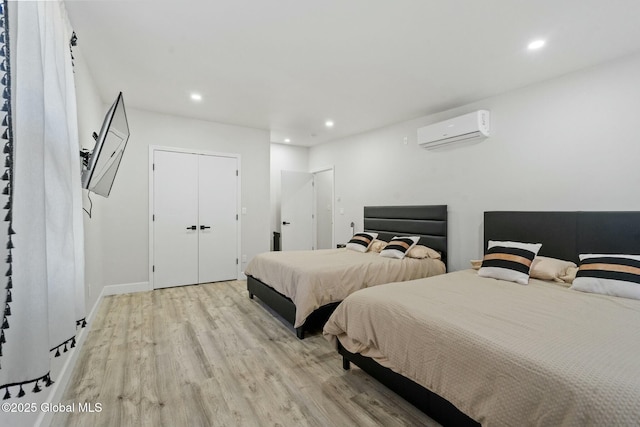 bedroom featuring recessed lighting, baseboards, a wall mounted air conditioner, and light wood finished floors