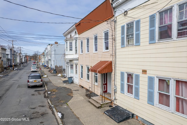 view of road featuring curbs, sidewalks, and a residential view