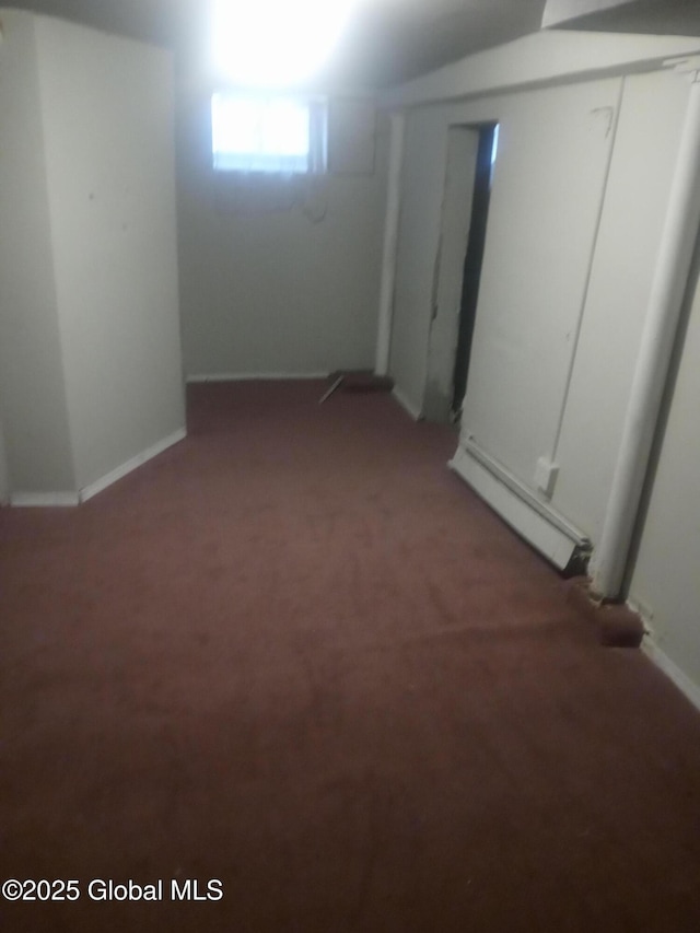 below grade area with light colored carpet and a baseboard radiator