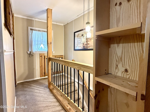 hallway featuring carpet, baseboards, crown molding, and an upstairs landing