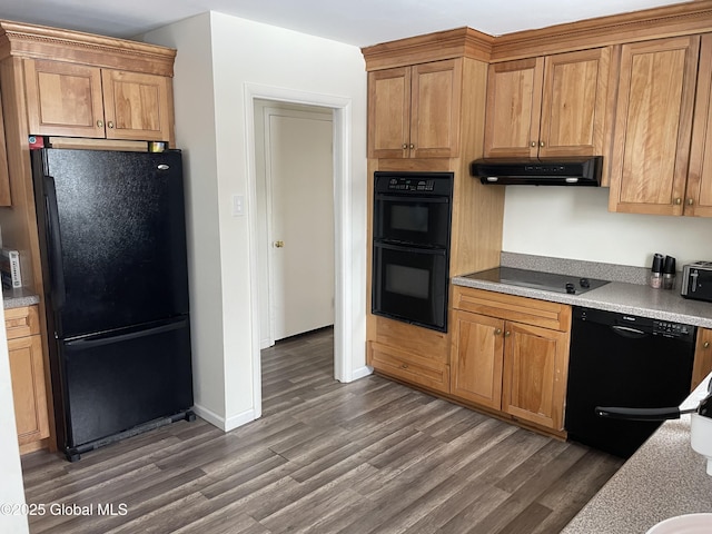 kitchen with baseboards, dark wood finished floors, under cabinet range hood, light countertops, and black appliances