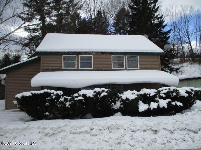 snow covered property featuring a garage