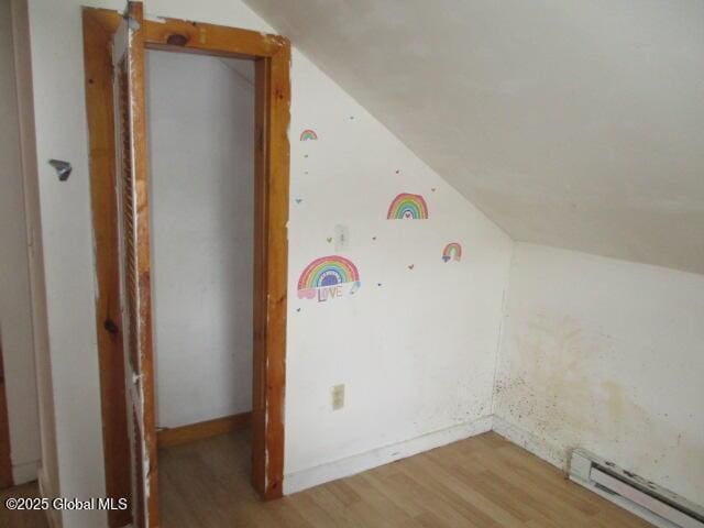 bonus room featuring a baseboard radiator, lofted ceiling, and light wood finished floors