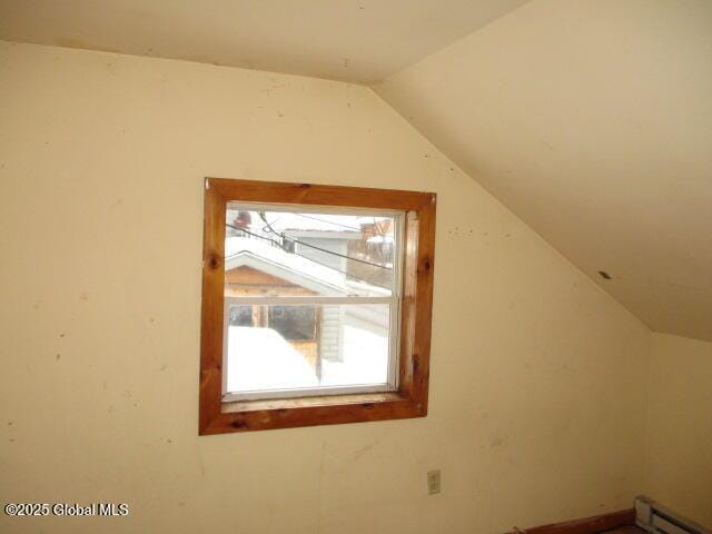 additional living space featuring a baseboard heating unit and vaulted ceiling