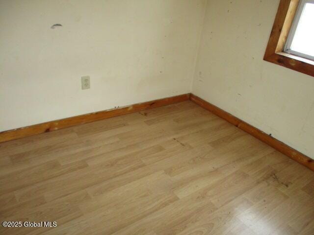 unfurnished room with light wood-style floors and baseboards