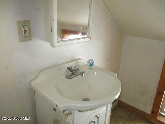 bathroom featuring lofted ceiling and vanity