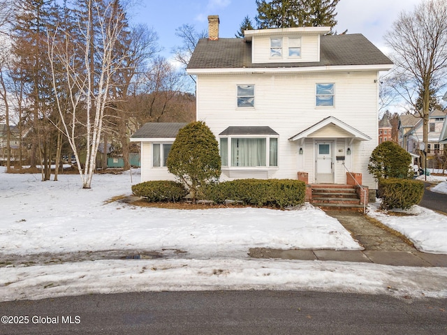 american foursquare style home featuring a chimney