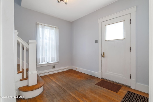 entryway featuring a healthy amount of sunlight, wood-type flooring, and baseboard heating