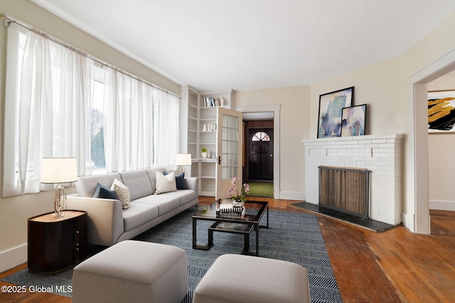 living area with a fireplace, wood finished floors, and baseboards