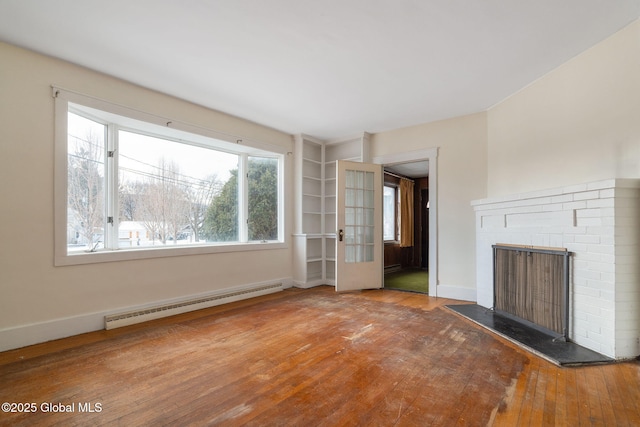 unfurnished living room with a fireplace, a baseboard radiator, wood-type flooring, and baseboards