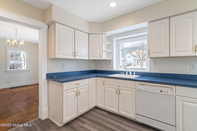 kitchen featuring dark wood finished floors, dishwasher, dark countertops, white cabinetry, and a sink