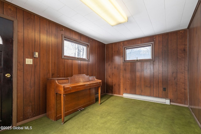 home office featuring a baseboard radiator, baseboards, wooden walls, and carpet