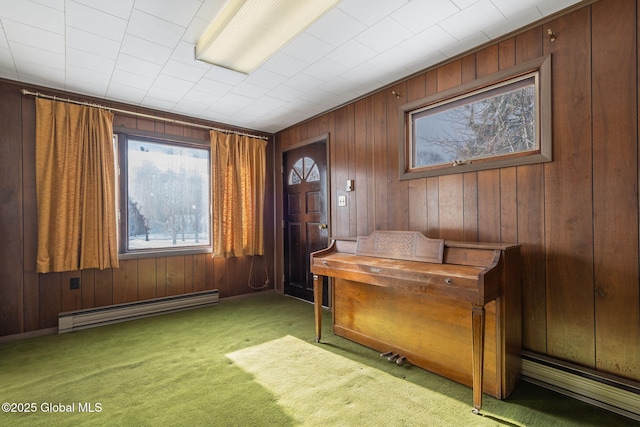 carpeted foyer featuring a baseboard heating unit and wooden walls