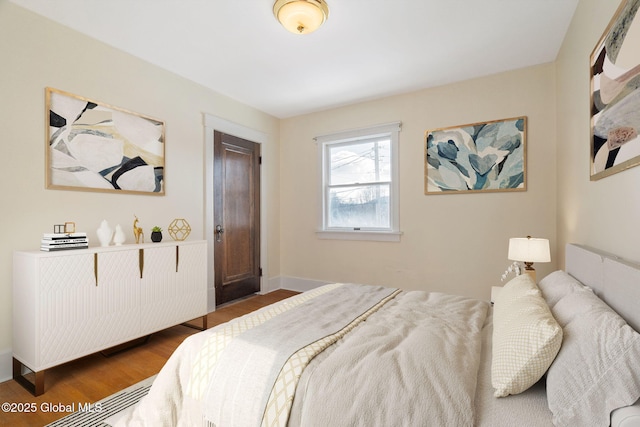 bedroom with dark wood-style flooring and baseboards