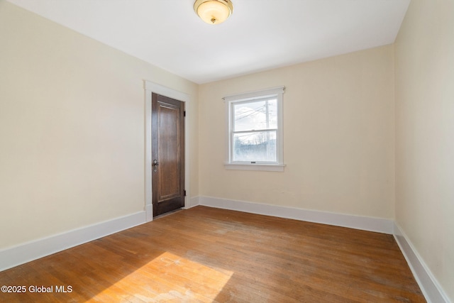 unfurnished room with light wood-type flooring and baseboards