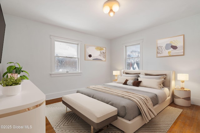 bedroom with baseboards and wood finished floors