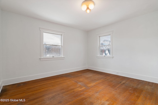 unfurnished room with hardwood / wood-style flooring and baseboards