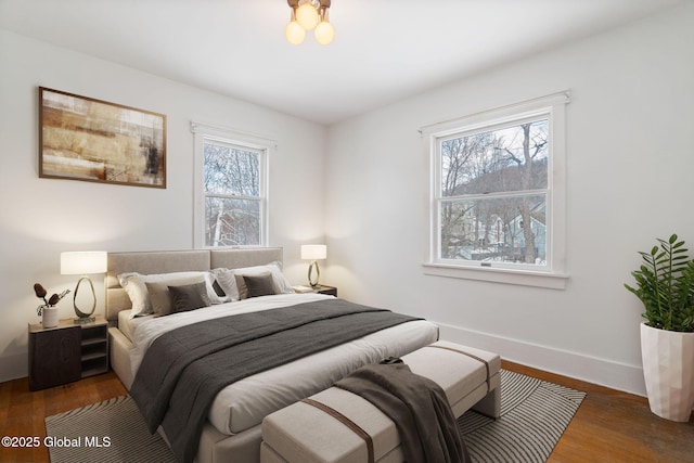 bedroom with baseboards and wood finished floors