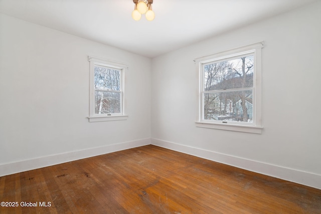 empty room with baseboards and hardwood / wood-style flooring