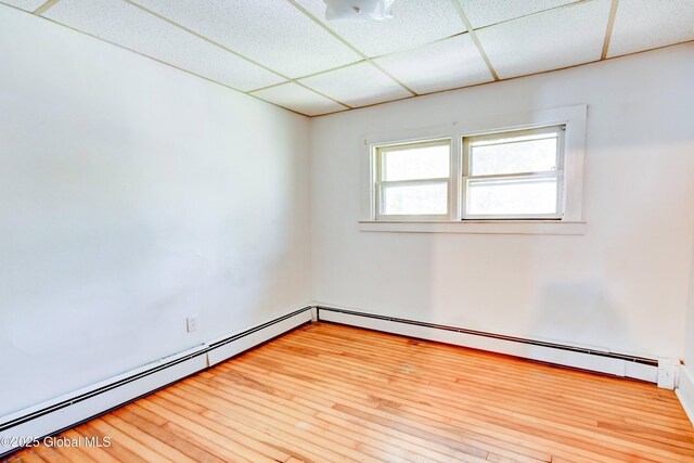 244 Kingsboro Ave, Gloversville, NY 12078 - unfurnished room with a baseboard heating unit, wood finished floors, and a drop ceiling