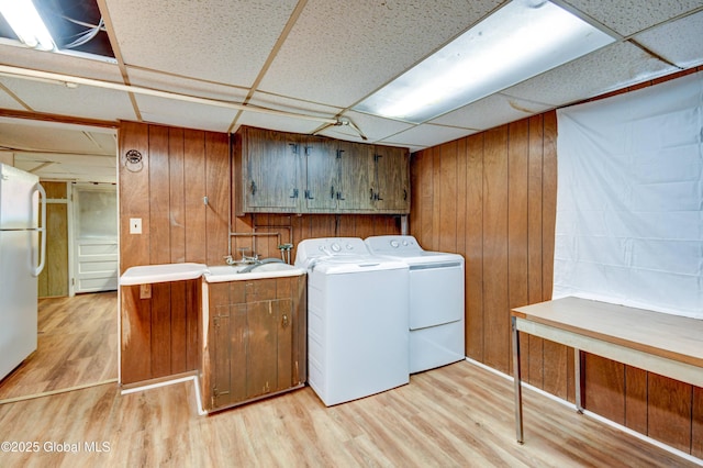 244 Kingsboro Ave, Gloversville, NY 12078 - laundry room featuring cabinet space, light wood-style flooring, washing machine and clothes dryer, and wood walls