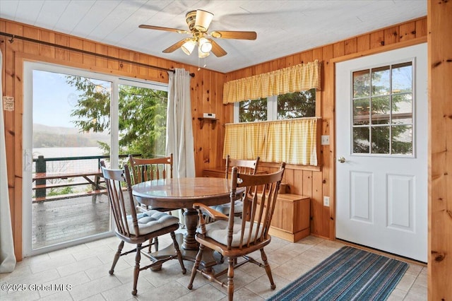 536 E Shore Dr, Horicon, NY 12808 - dining room featuring wood walls, healthy amount of natural light, ceiling fan, and light tile patterned floors