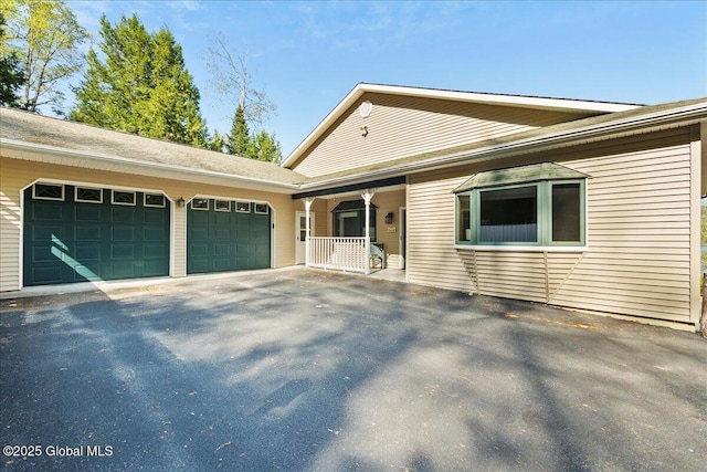 536 E Shore Dr, Horicon, NY 12808 - ranch-style house featuring a garage, asphalt driveway, and a porch