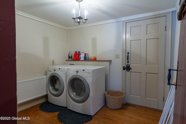 washroom with wood finished floors, laundry area, radiator heating unit, separate washer and dryer, and ornamental molding