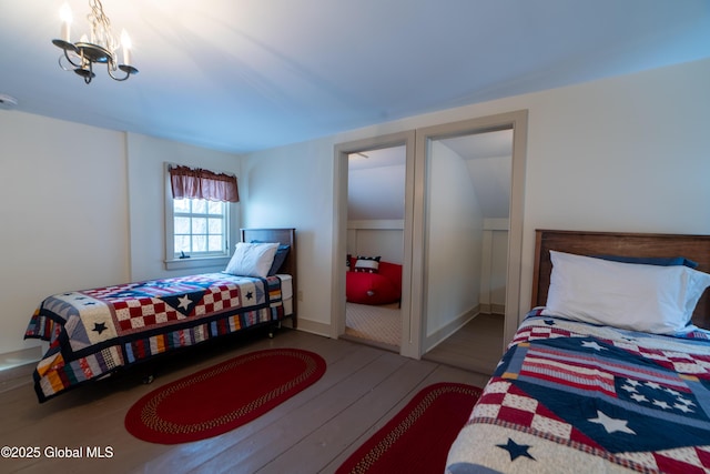 bedroom featuring a chandelier and wood finished floors